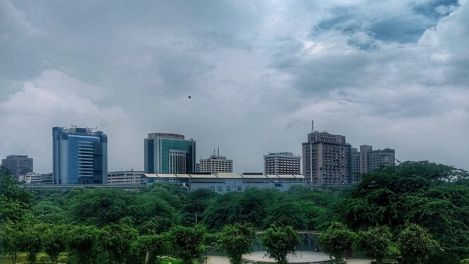Skyline of Nehru Place IT park, Delhi seen from Astha Kunj park. In the forefront is the metro station