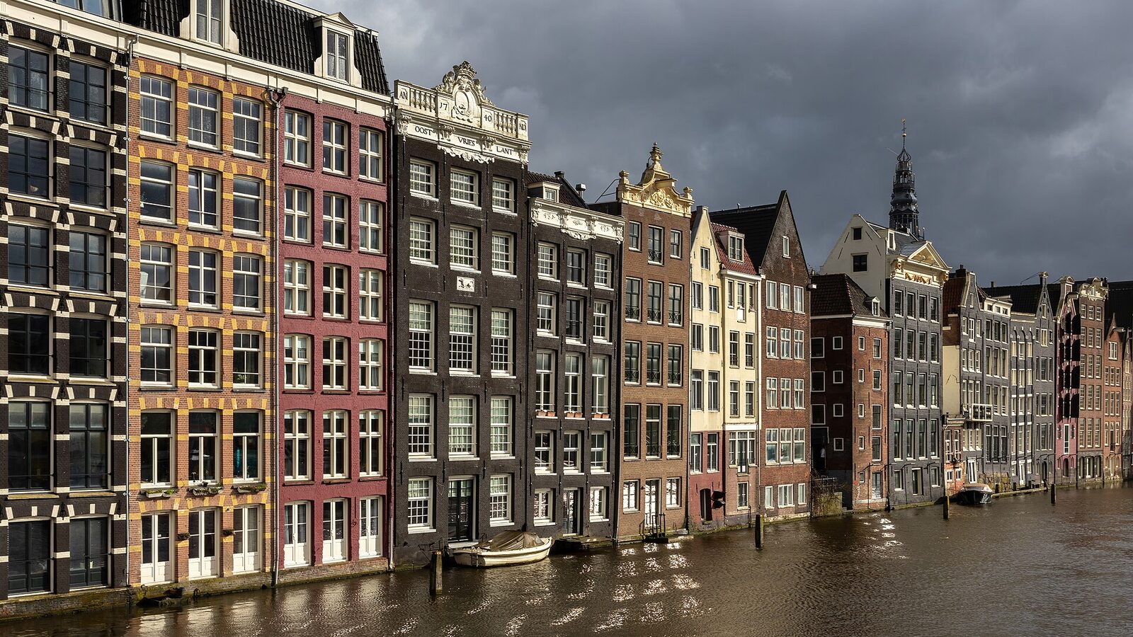 Colorful canal houses at golden hour in Damrak avenue Amsterdam the Netherlands