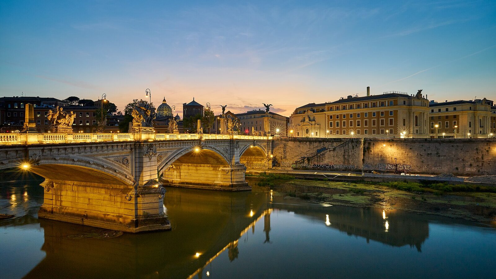 Ponte Vittorio Emanuele II (bridge) in Rome (Italy) at the blue hour. The dome of St Peter's Basilica (Basilica Sancti Petri) in the Vatican can…