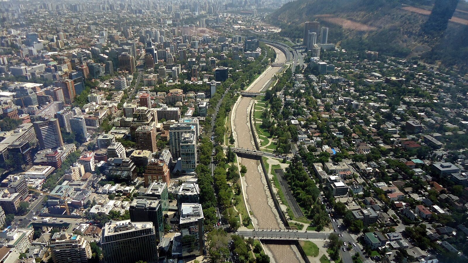 Downtown Santiago de Chile and Mapocho river from the watching deck of the Gran Torre Santiago. In the center, Parque Uruguay