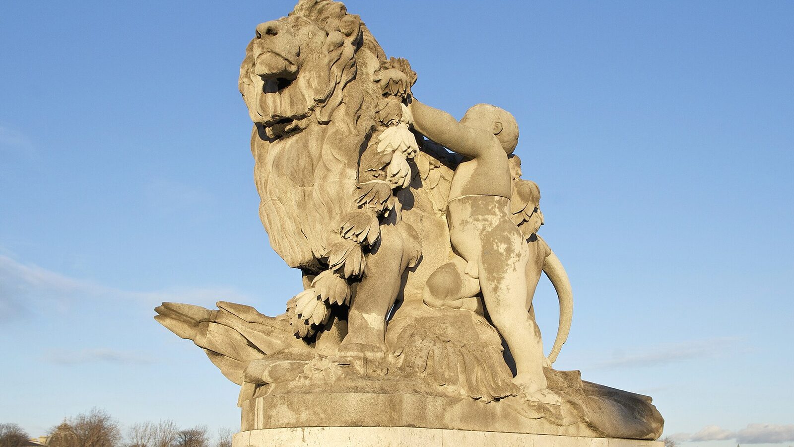 "Lion et génie" or "Lion guided by a child", stone. Alexandre III bridge, Paris. Sunset light