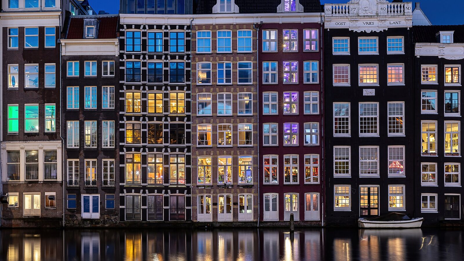 Water reflection of canal houses at blue hour in Damrak Amsterdam the Netherlands